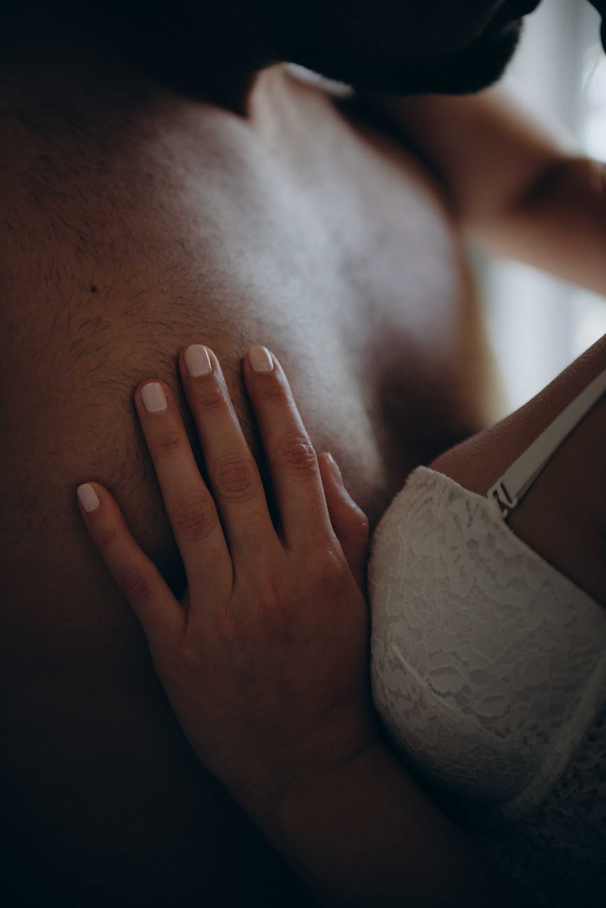 woman wearing white bra holding man s chest