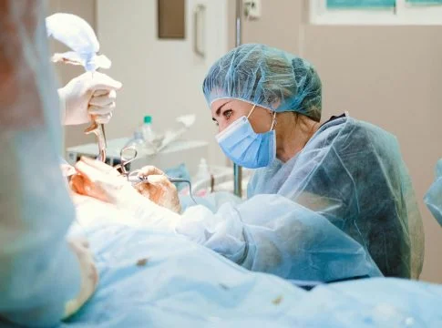 woman doing a surgery on a patient