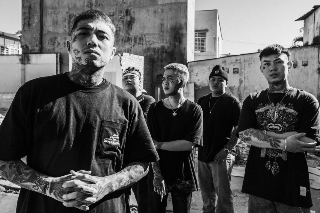 cool asian gang with tattoos on city street