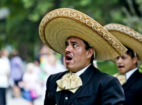 man s black blazer and brown traditional hat