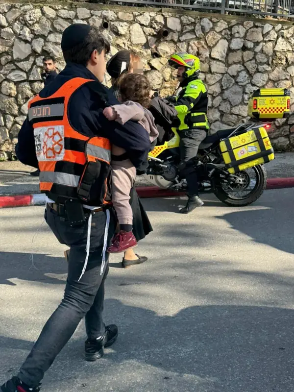 Спасатель несет малыша  в Иерусалиме